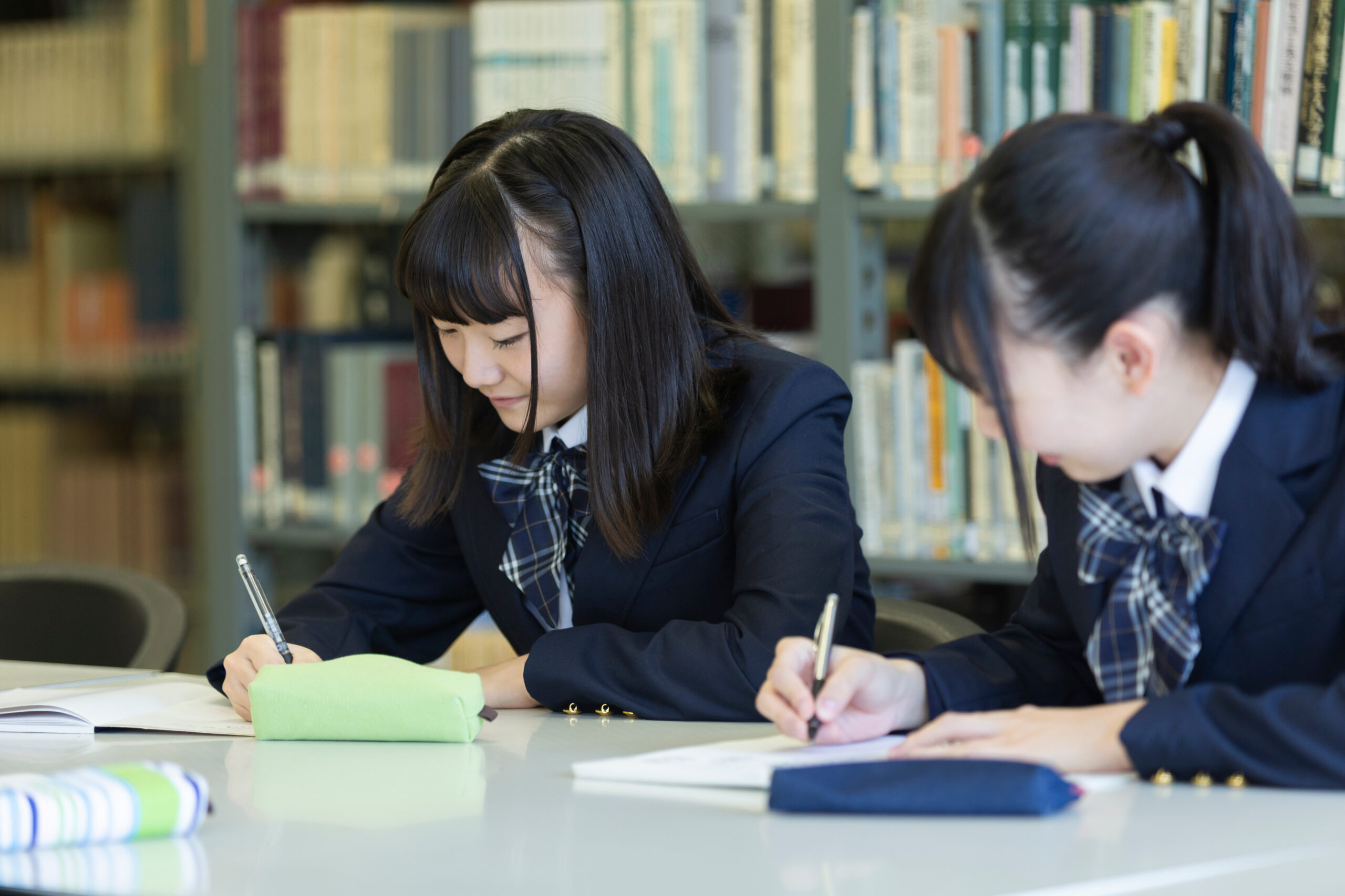 two high school girls studying in the library